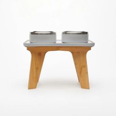 two bowls are sitting on top of a small table that is made out of wood