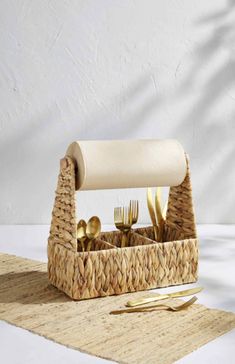 a basket with utensils in it sitting on a table