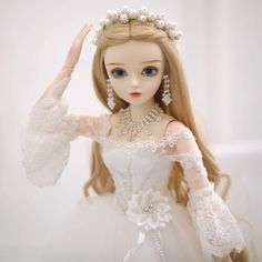 a doll wearing a white dress and tiara