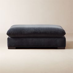 a black ottoman sitting on top of a white floor