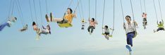 a group of people swinging on swings in the air with their feet dangling off them