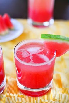 two glasses filled with watermelon juice on top of a table