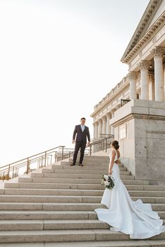 a bride and groom walking up some steps