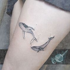 two whale tattoos on the legs of a woman's leg, one is black and white