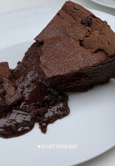 two pieces of brownie on a plate with chocolate sauce in the middle and one piece cut out