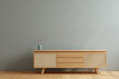 an empty room with a sideboard and vase on the floor