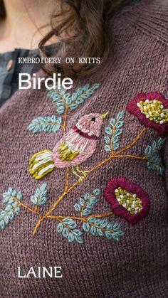 a close up of a woman wearing a sweater with flowers on it and the text embroidery on knits birdie