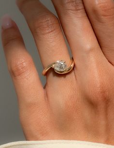 a woman's hand with a diamond ring on top of her finger and the other hand holding it