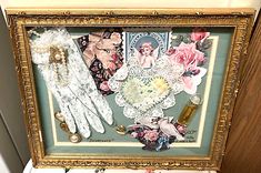 an ornate framed picture with lace, gloves and flowers on the bottom half of it