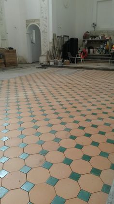 the floor is covered with blue and pink tiles in an old building that's being renovated