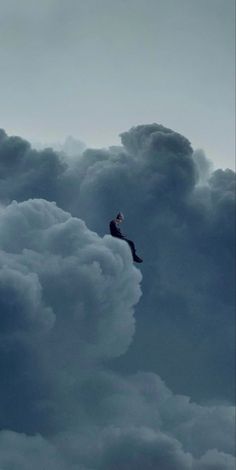 a man sitting on top of a cloud in the sky