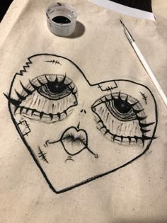 a heart with two eyes drawn on it next to a pen and ink rollers