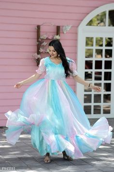 a woman in a blue and pink dress is dancing