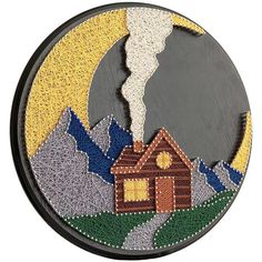 a round painting with a house and mountains in the background