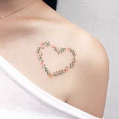 a woman with a heart shaped tattoo on her shoulder