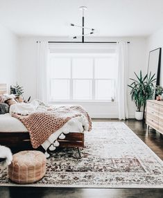 a bed room with a neatly made bed and a rug