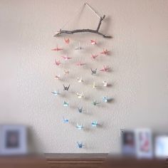 there is a wall hanging made out of origami birds on a tree branch