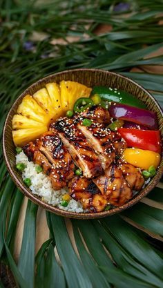 a close up of a plate of food with pineapples and chicken on it