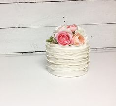 a small white cake with pink flowers on top