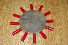 a wooden table topped with red candles and a round object on it's side