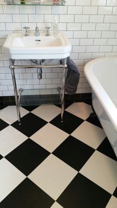 a black and white checkered floor in a bathroom with a claw foot bathtub