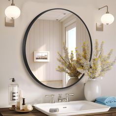 a bathroom sink with a mirror above it and flowers in a vase on the counter