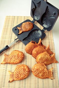 four fish shaped pans sitting on top of a mat next to an egg tray