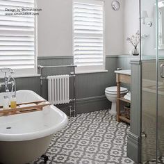 a bathroom with a bathtub, sink and toilet next to a window covered in blinds