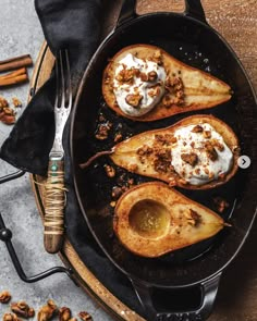 baked pears in a cast iron skillet with whipped cream and walnuts on the side