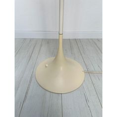 a white table lamp sitting on top of a wooden floor