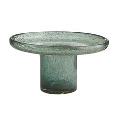 a green glass bowl sitting on top of a table