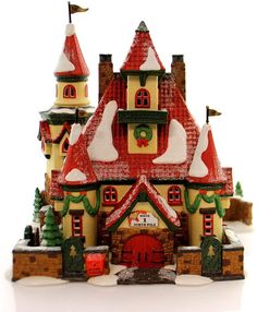 a toy house with snow on the roof and christmas decorations around it's windows