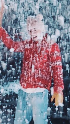 a man standing in the rain with his hands up