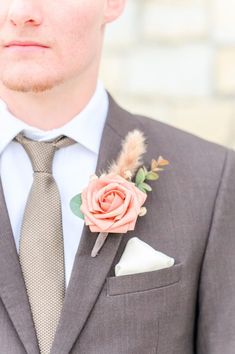 a man in a suit with a boutonniere and flower on his lapel