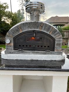 an outdoor pizza oven sitting on top of a table