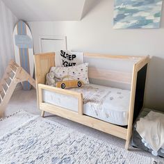 a child's bedroom with a wooden bed and toy car on the floor next to it