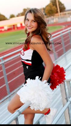 a girl in a cheerleader outfit posing on the bleachers