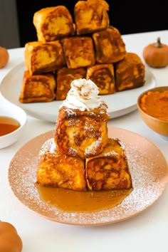 some food is sitting on a plate and next to other plates with pumpkins in the background