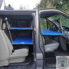 the interior of a van with two blue shelves on it's back door and one open