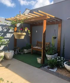 an outdoor patio with potted plants and hanging planters on the side of it