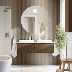 a white bath tub sitting next to a bathroom sink under a round mirror on a wall