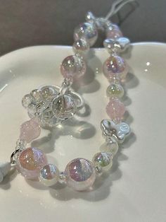 a close up of a bracelet on a plate with a bead and glass charm