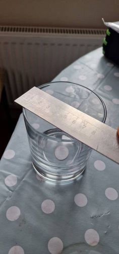 a knife sticking out of a glass on top of a polka dot covered table cloth