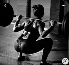 a woman squats while holding a barbell