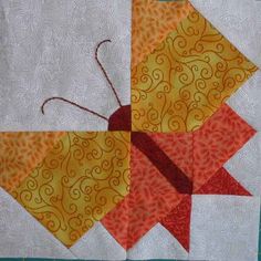 an orange and yellow quilted object with red thread