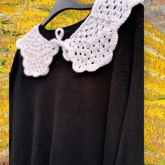 a black shirt with white crochet on it