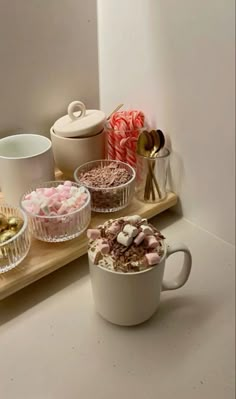 there are three cups on the table with candy in them and marshmallows