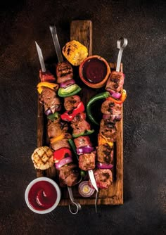 skewered meat and vegetables on a wooden tray with ketchup