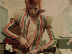 a man with red hair is cutting up food in the middle of a kitchen area