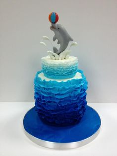 a blue and white cake with a dolphin on top